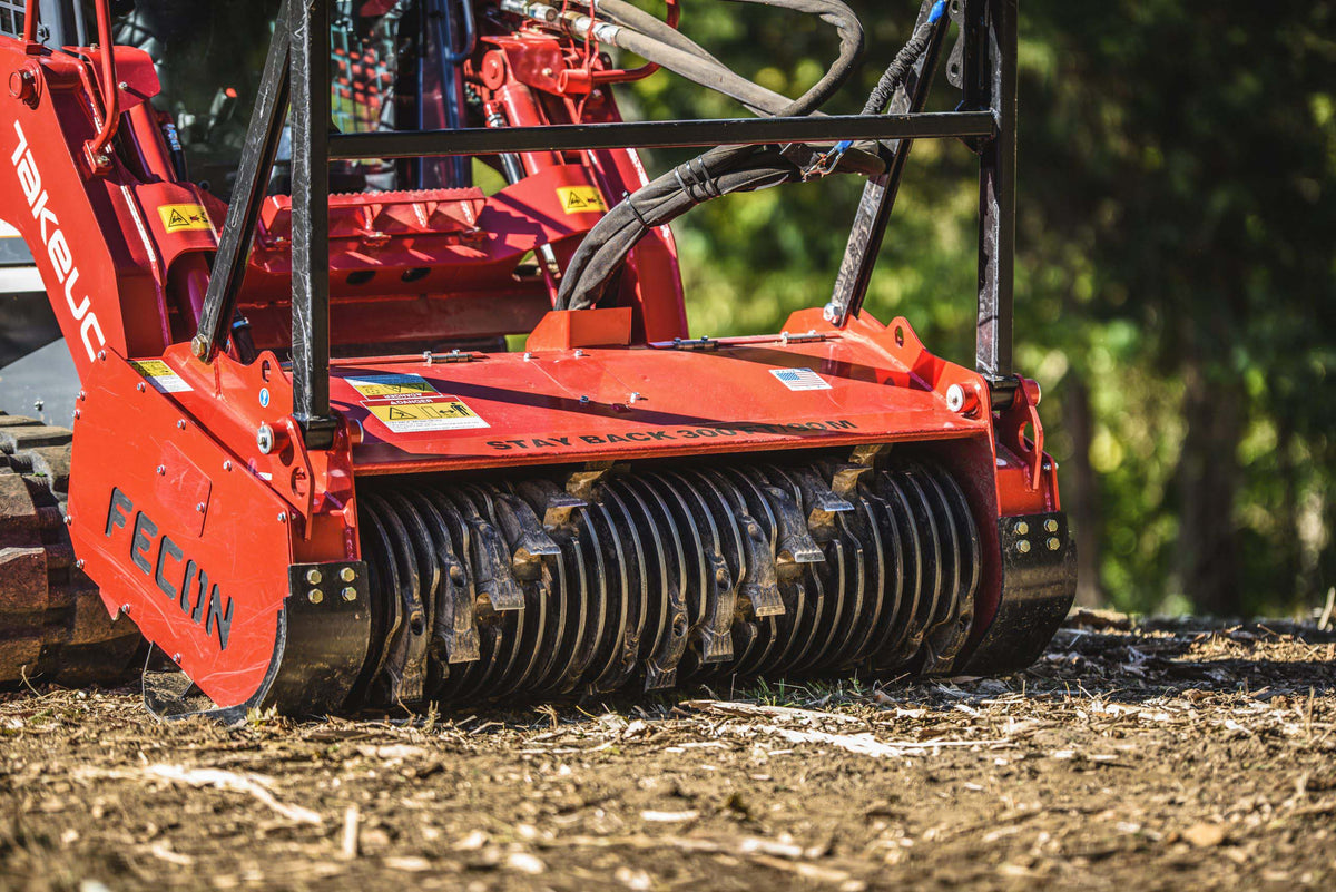 Close-up of a FECON Bull Hog mulcher cutting drum at a forestry site