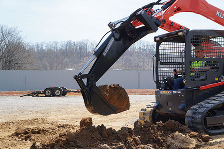 Blue Diamond Backhoe — mounted on a compact track loader digging soil
