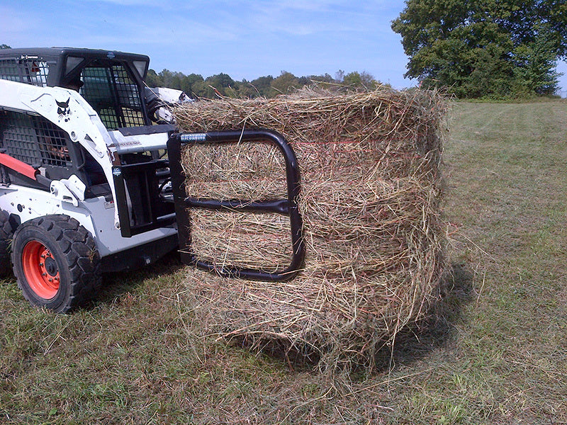 Blue Diamond Bale Squeeze — Hydraulic Round — mounted on a skid steer carrying a round hay bale