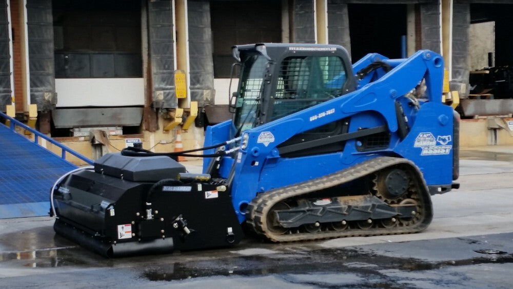 Blue Diamond Series 2 Pickup Broom — mounted on a compact track loader sweeping pavement