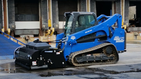 Blue Diamond Series 2 Pickup Broom — mounted on a compact track loader sweeping pavement