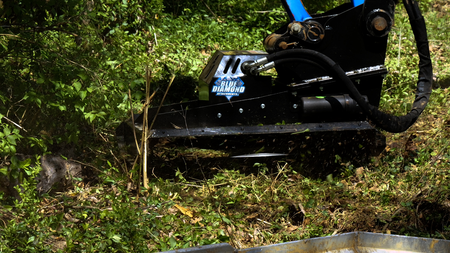 Close-up of Blue Diamond heavy duty mini excavator brush cutter cutting vegetation