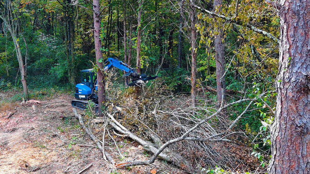 Mini excavator using Blue Diamond heavy duty brush cutter for land clearing
